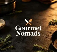 The Gourmet Nomads mark on a warmly lit culinary surface